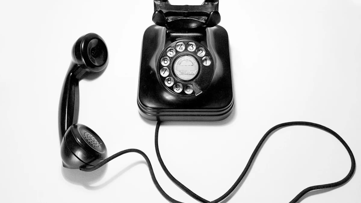 Un classico telefono nero in bachelite con selettore a disco vintage, posizionato su sfondo bianco minimale