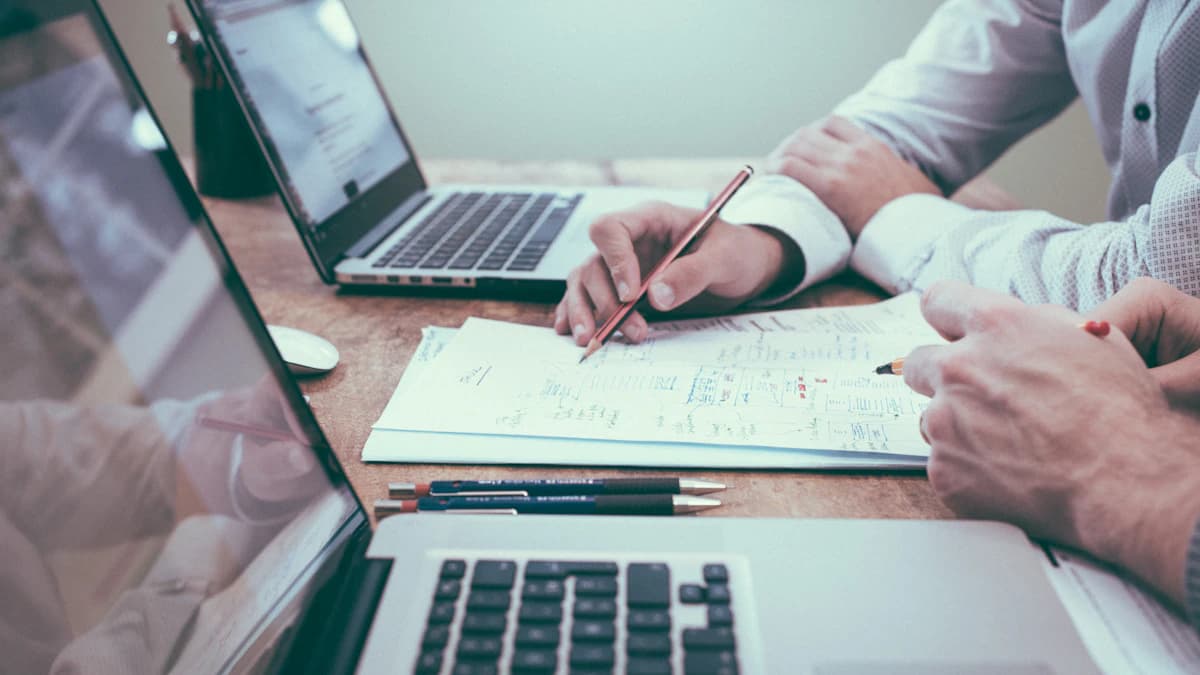 Postazione di lavoro ordinata con laptop, taccuino, tazza di caffè e occhiali per l'ottimizzazione SEO strategica